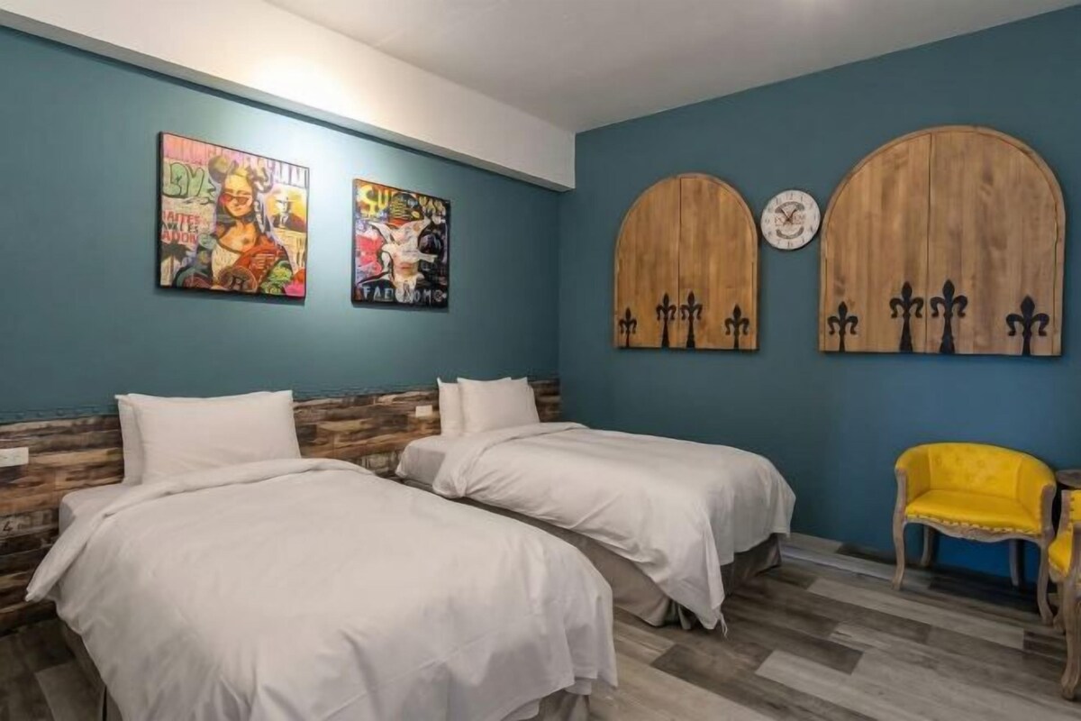 A room with two beds, a clock, and two wall-mounted wooden doors.