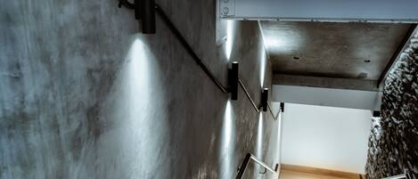 A staircase with metal railings and a concrete wall.