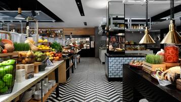 A modern kitchen with a black and white chevron floor pattern, wooden countertops, and various fruits and vegetables displayed on the counter.