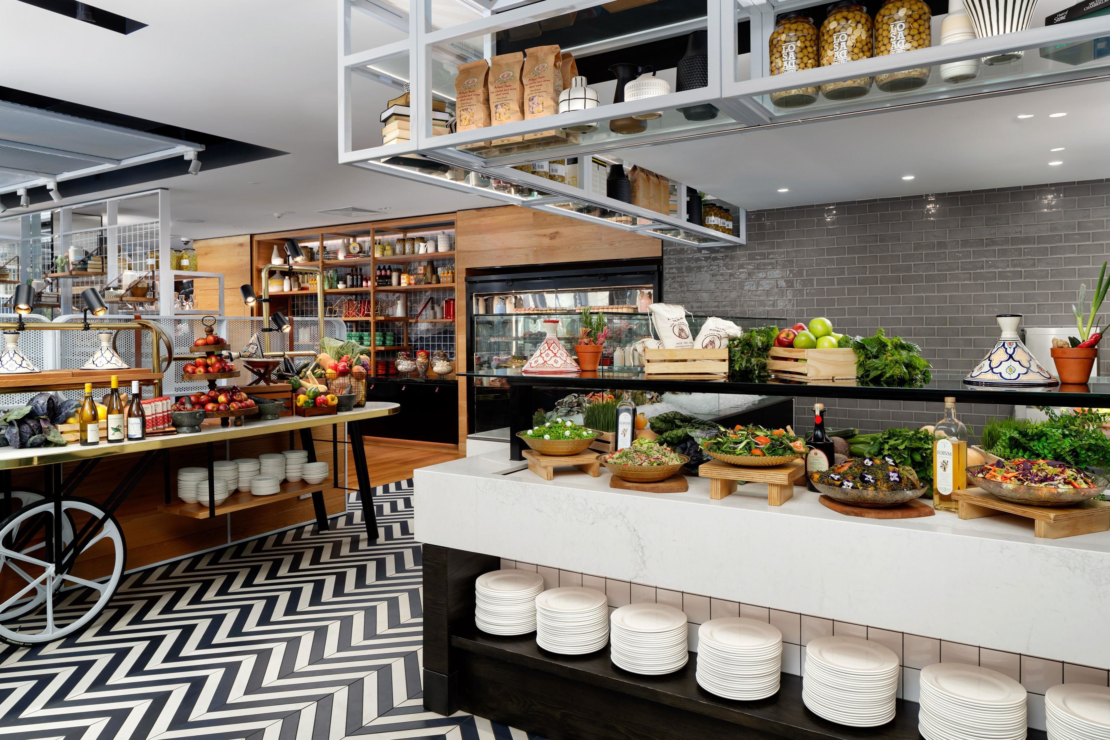 A modern kitchen with a marble countertop, stocked with fresh produce and cooking utensils.