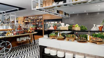 A modern kitchen with a marble countertop, stocked with fresh produce and cooking utensils.
