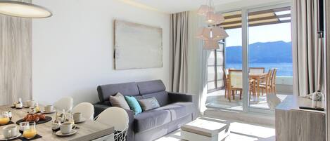 En moderne stue med spiseplads, en sofa og havudsigt.