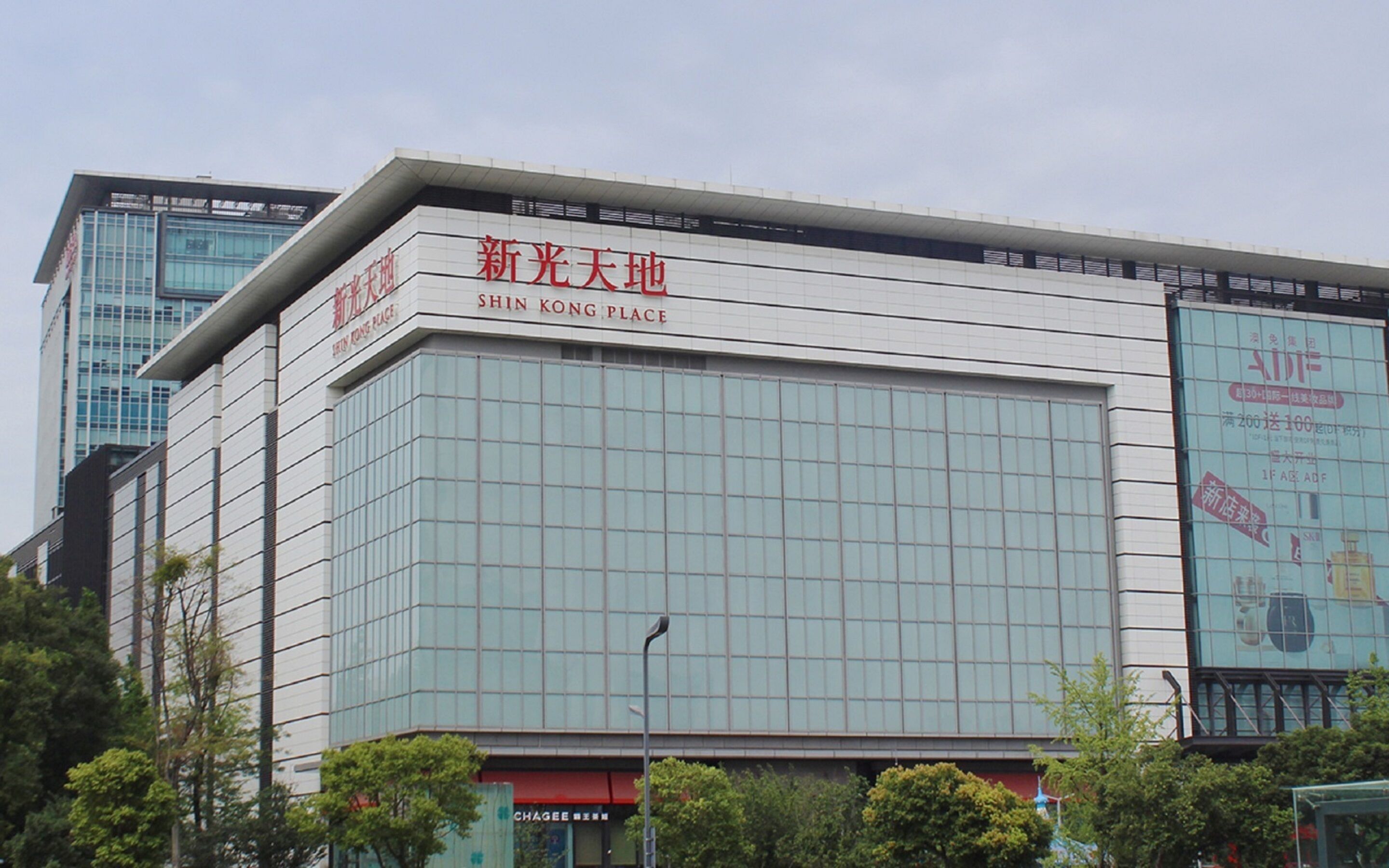 A modern building with large glass windows and signage indicating it is the "Shin Kong Place."