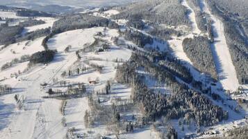 Un paisaje montañoso cubierto de nieve con senderos de esquí.