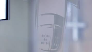 Una pared de vidrio con una imagen borrosa de un teléfono y una bandera.