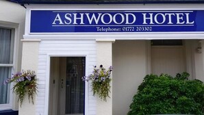 Exterior del Hotel Ashwood, con un llamativo letrero azul que muestra el nombre y el número de teléfono.