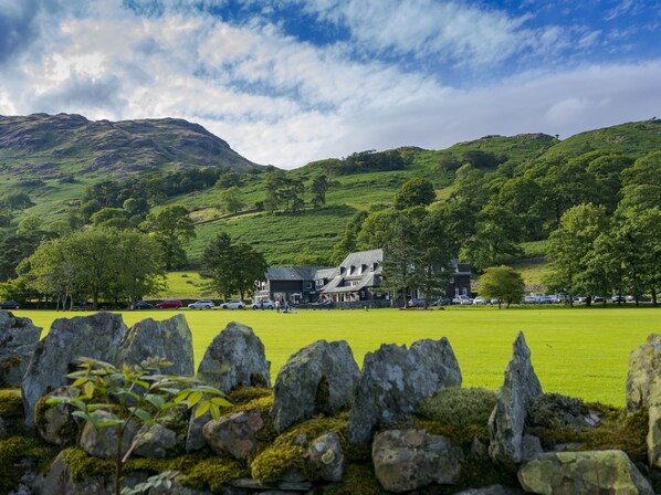 A large house with a grassy lawn and a stone wall in the foreground. - Glaramara Hotel (Keswick)