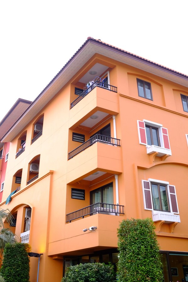 A multi-story building with balconies, large windows, and a flat roof.