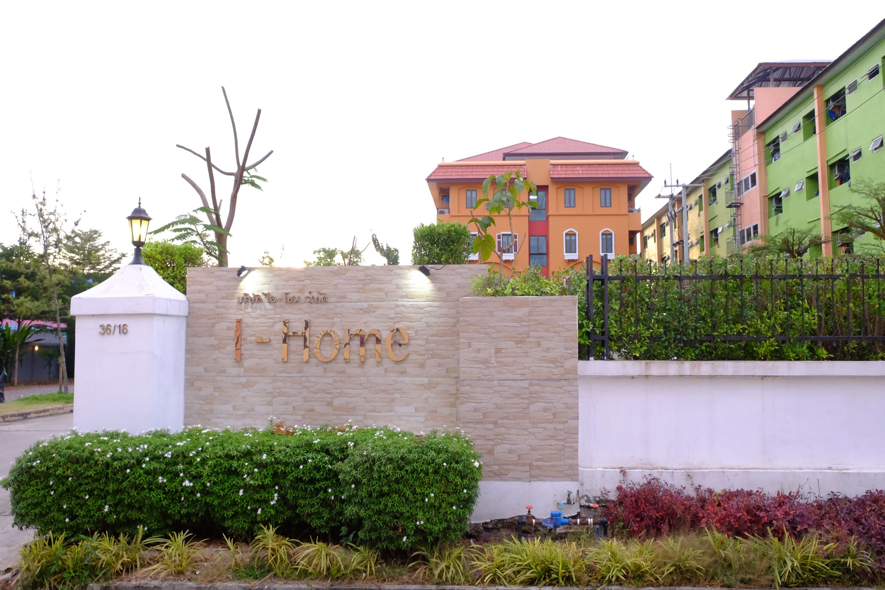A sign with "I-Home" and a building with a red roof.