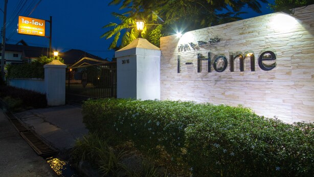 A well-lit entrance with a sign reading "I-Home" and a street sign in the background. - I-Home Residence and Hotel (Pluak Daeng)