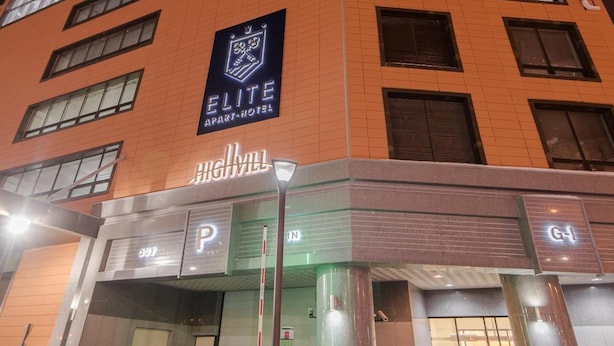 A high-rise building with a prominent "ELITE APART-HOTEL" sign.