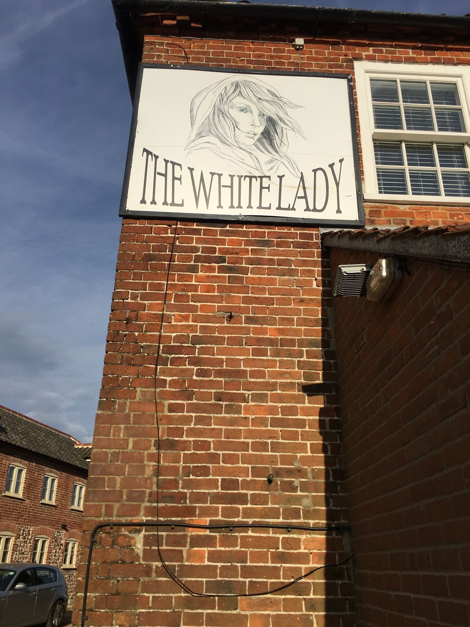 Un edificio de ladrillo con un letrero que dice "The White Lady".