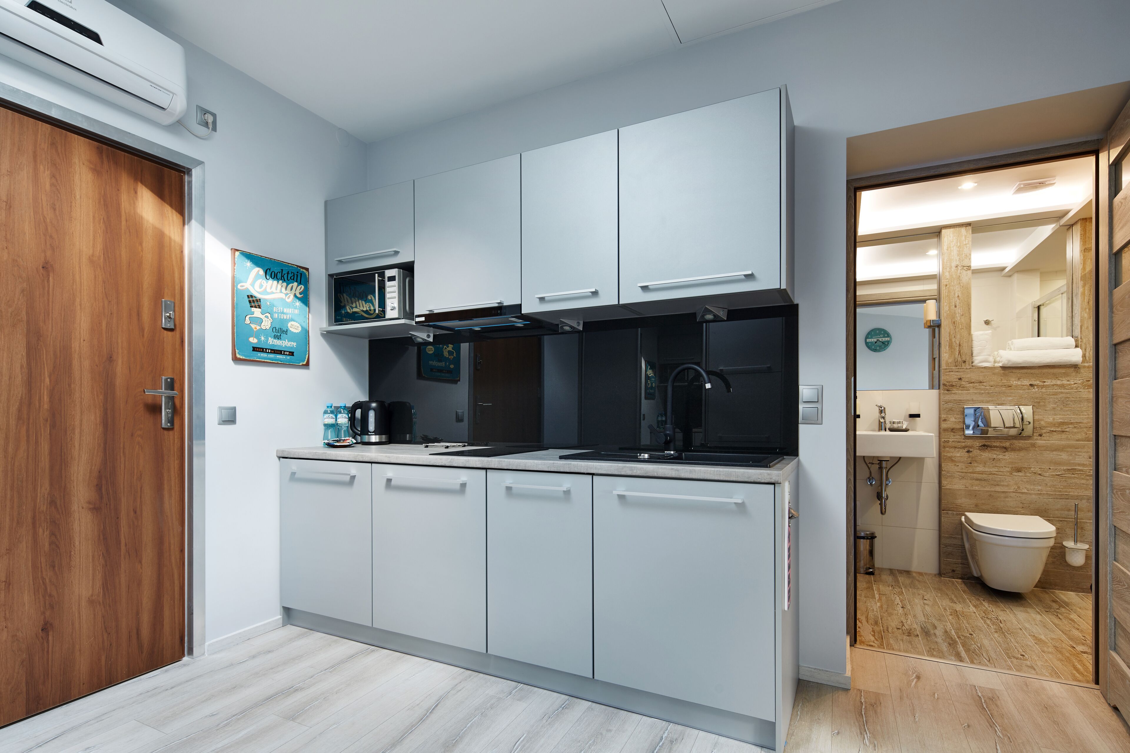 A modern kitchen with white cabinets, a microwave, and a coffee maker.