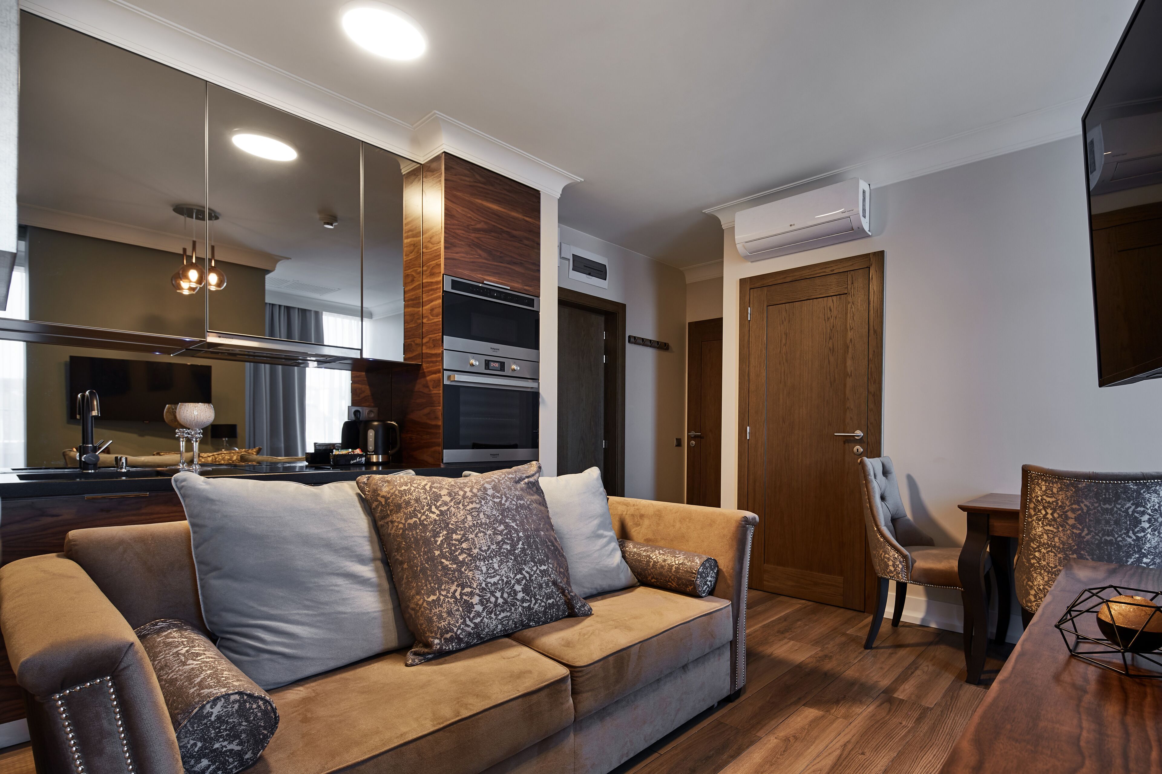 Un salón moderno con un sofá, una mesa de comedor y una cocina al fondo.