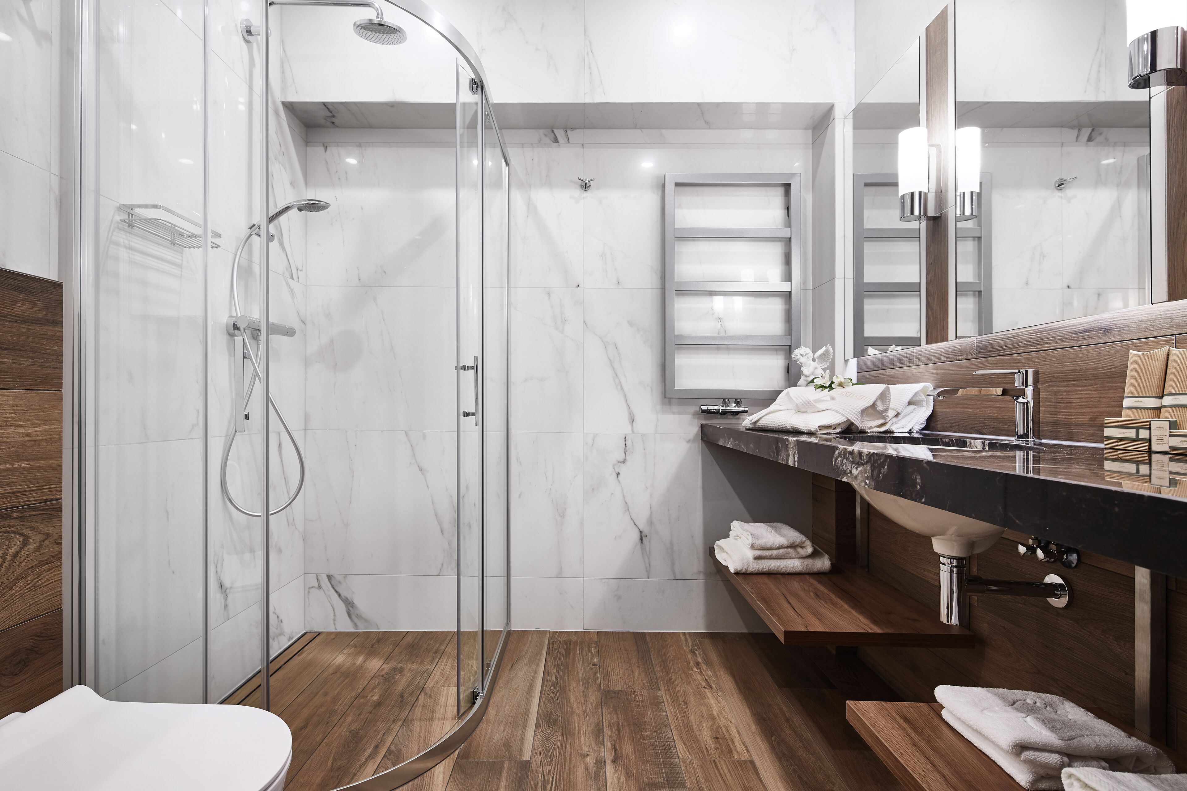 A modern bathroom with a glass-enclosed shower, a wooden vanity, and a large mirror.