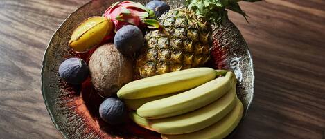 Ein Teller mit Obst, darunter Ananas, Drachenfrucht, Kiwi und Bananen.