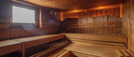 Una sauna con bancos de madera y una ventana.