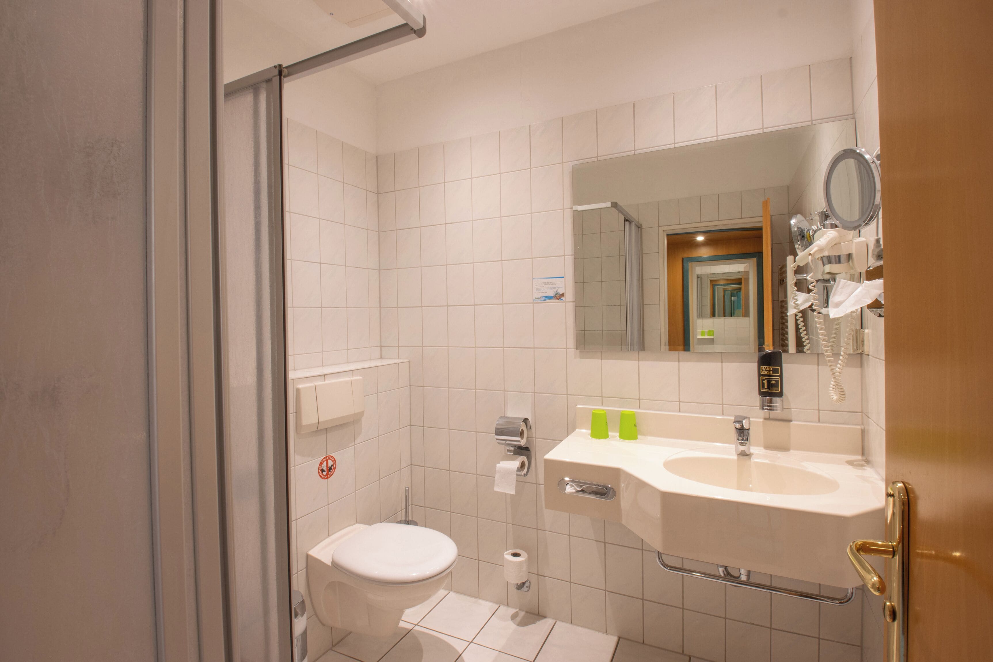 Un baño con inodoro, lavabo y espejo.