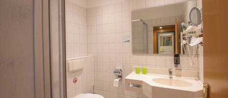 Un baño con inodoro, lavabo y espejo.
