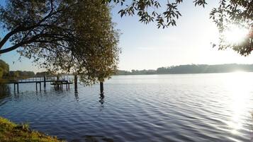 A calm lake with a dock and trees.