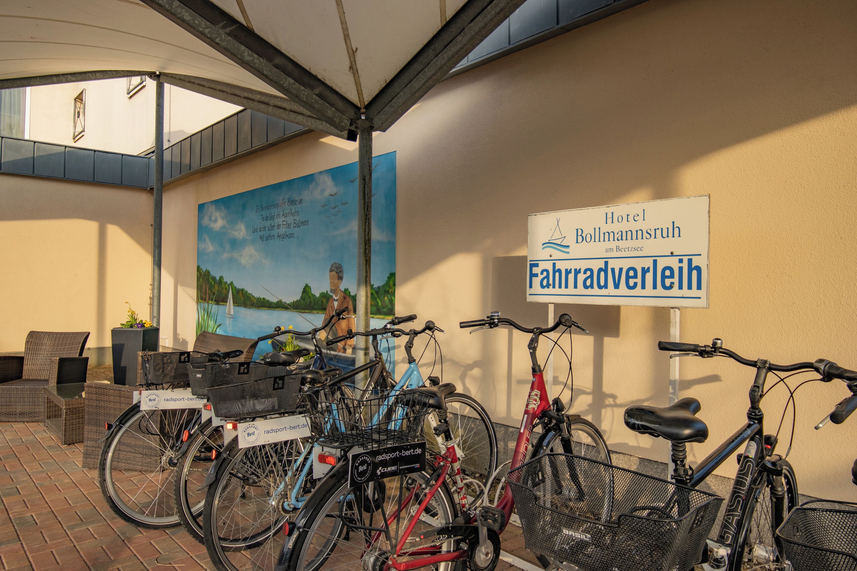 Bicicletas estacionadas frente a un edificio con un letrero que dice "Hotel Bollmannsruh Fahradverleih".