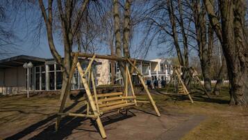 Guests can enjoy a serene atmosphere in this park setting, surrounded by mature trees and a paved walkway.