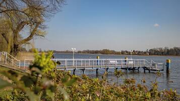 A pier extending into a calm body of water, surrounded by trees and vegetation.