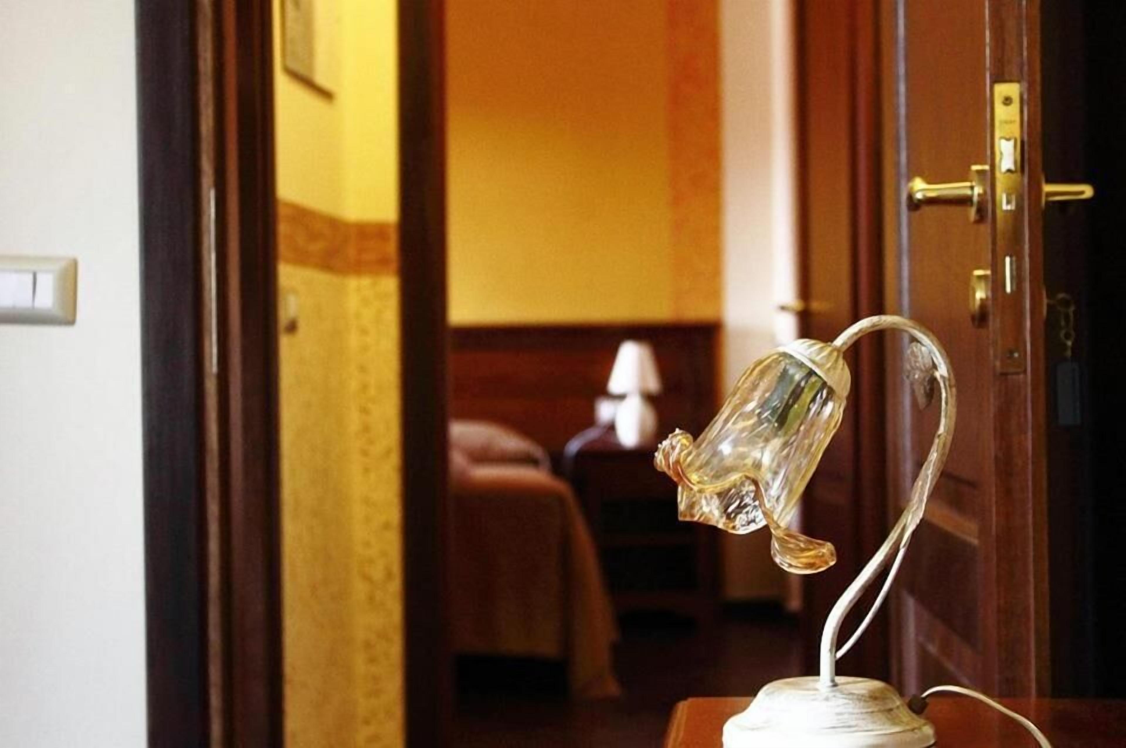 A room with a bed, a nightstand, and a lamp.