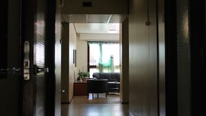 A hallway leading to a living room with a sofa and a potted plant. - Guesthouse Kuin Kotonaan (Kotka)