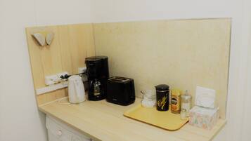 Eine Küchenzeile mit Waschmaschine, Kaffeemaschine, Toaster und Schneidebrett.