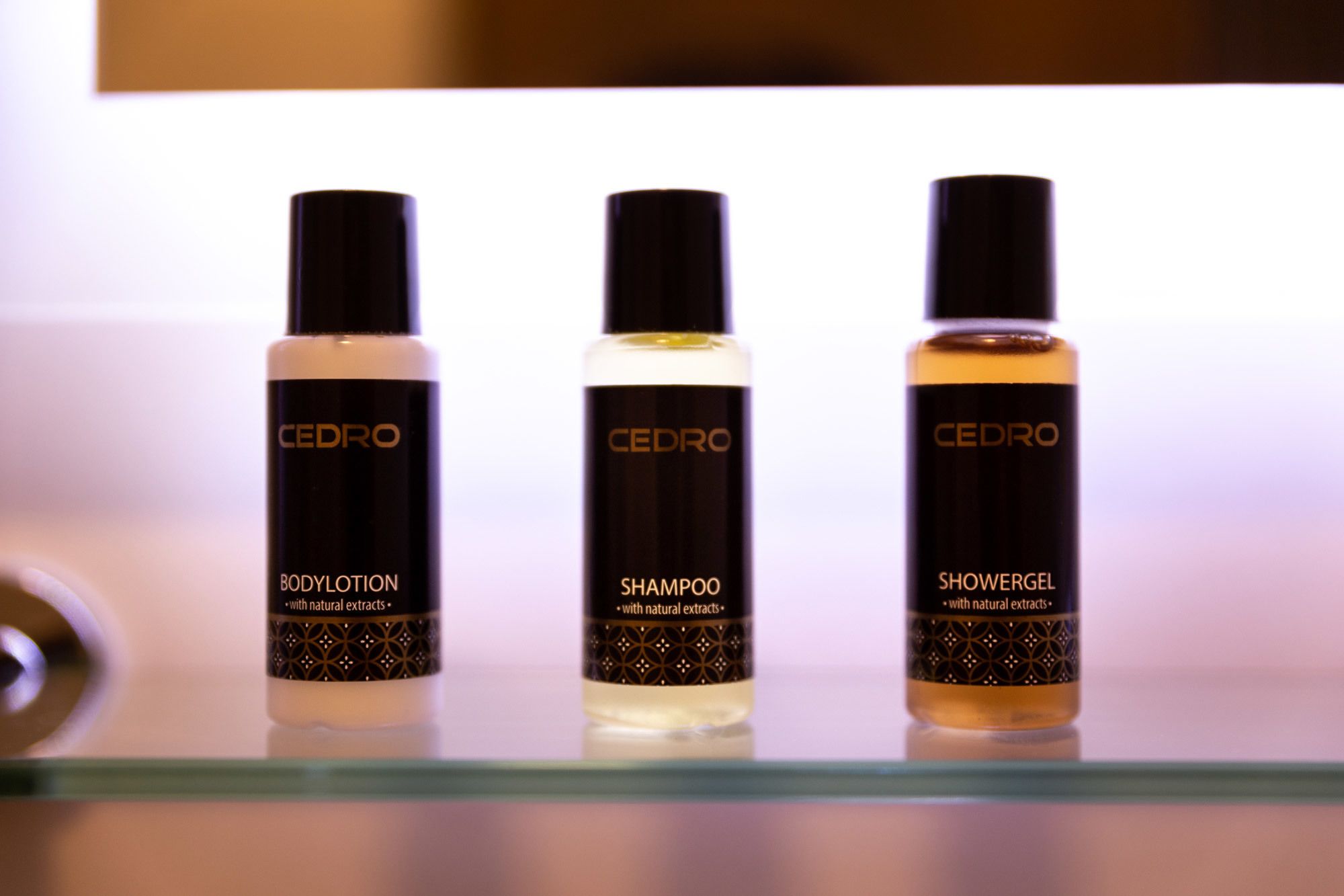 Three bottles of Cedro body products on a shelf.