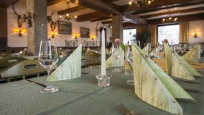 Een eettafel gedekt met wijnglazen, een kaars en een bloem.