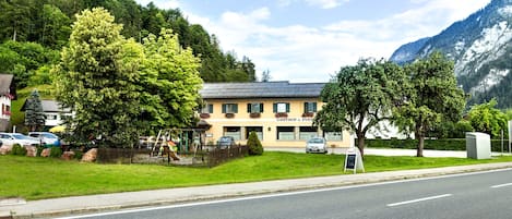 Un edificio con un letrero que dice "Gasthof a. Fleisch" en un entorno rural, con una carretera al frente.