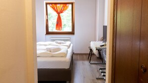 Een slaapkamer met een bed, bureau en garderobekast.