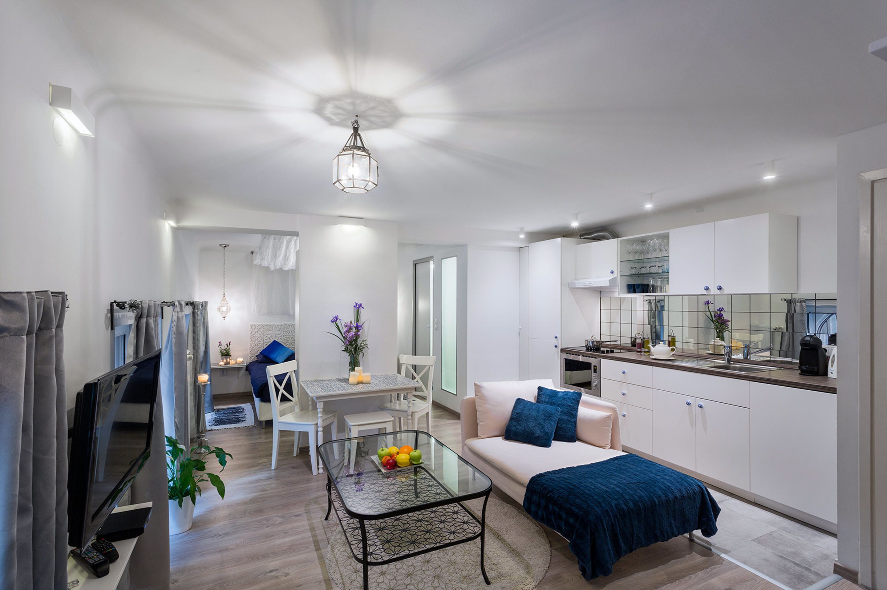 A modern apartment with a living room, dining area, and kitchen.