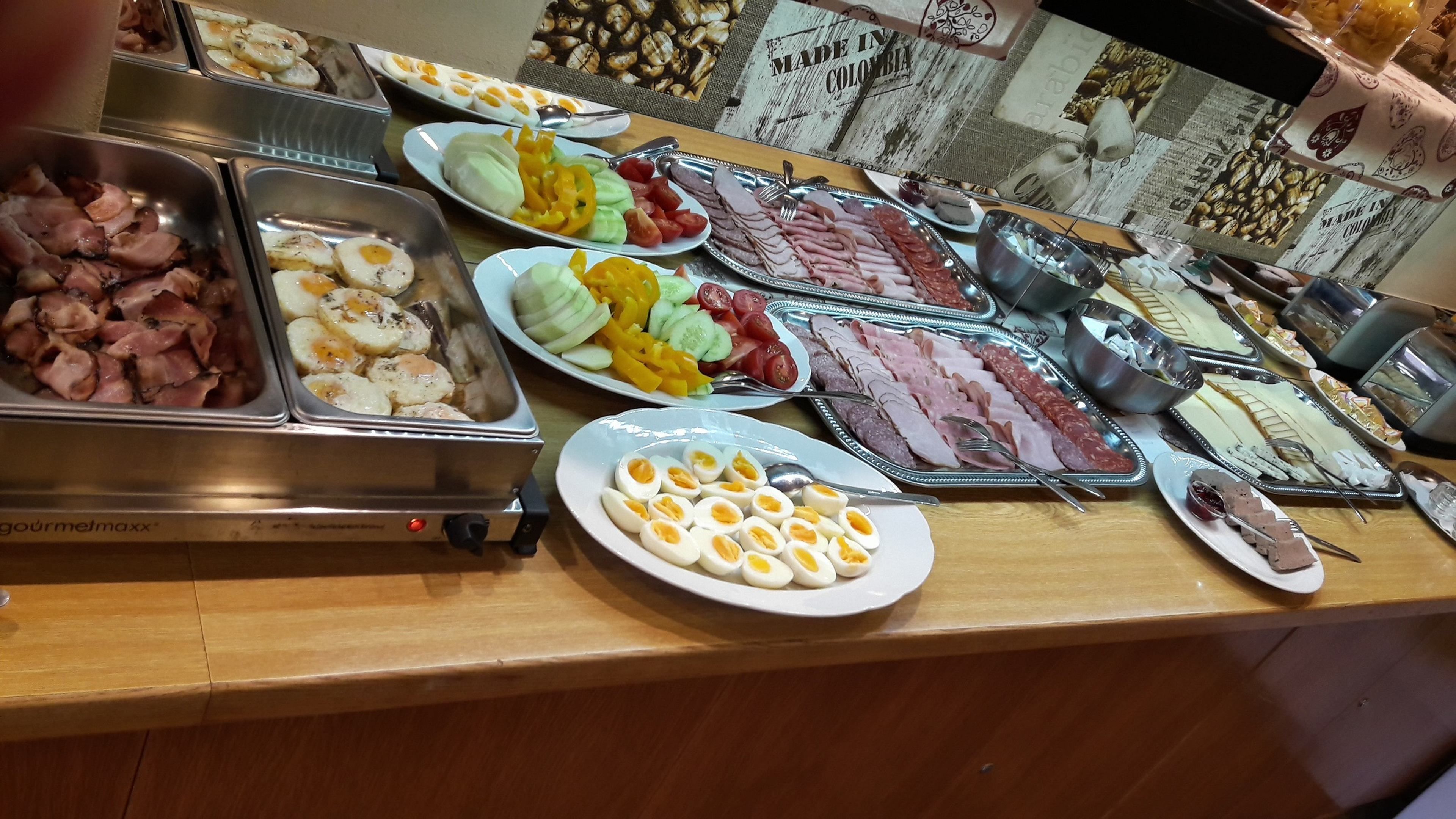 A buffet with various food items including meats, eggs, and vegetables.