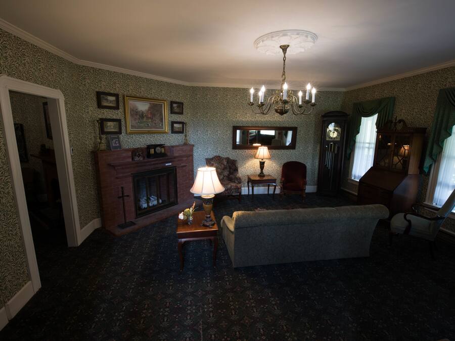 A traditional living room with a fireplace, a chandelier, and a sofa.