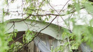 A tented area with lush greenery and a dining setup. - Interlaken Inn & Resort (Lakeville)