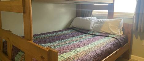 A bunk bed with a quilted bedspread and pillows.