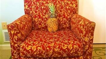 A red patterned armchair with a pineapple on it.