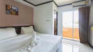 A hotel room with a large bed, a painting on the wall, and an air conditioning unit. - Kulasab Hotel (Hat Yai)
