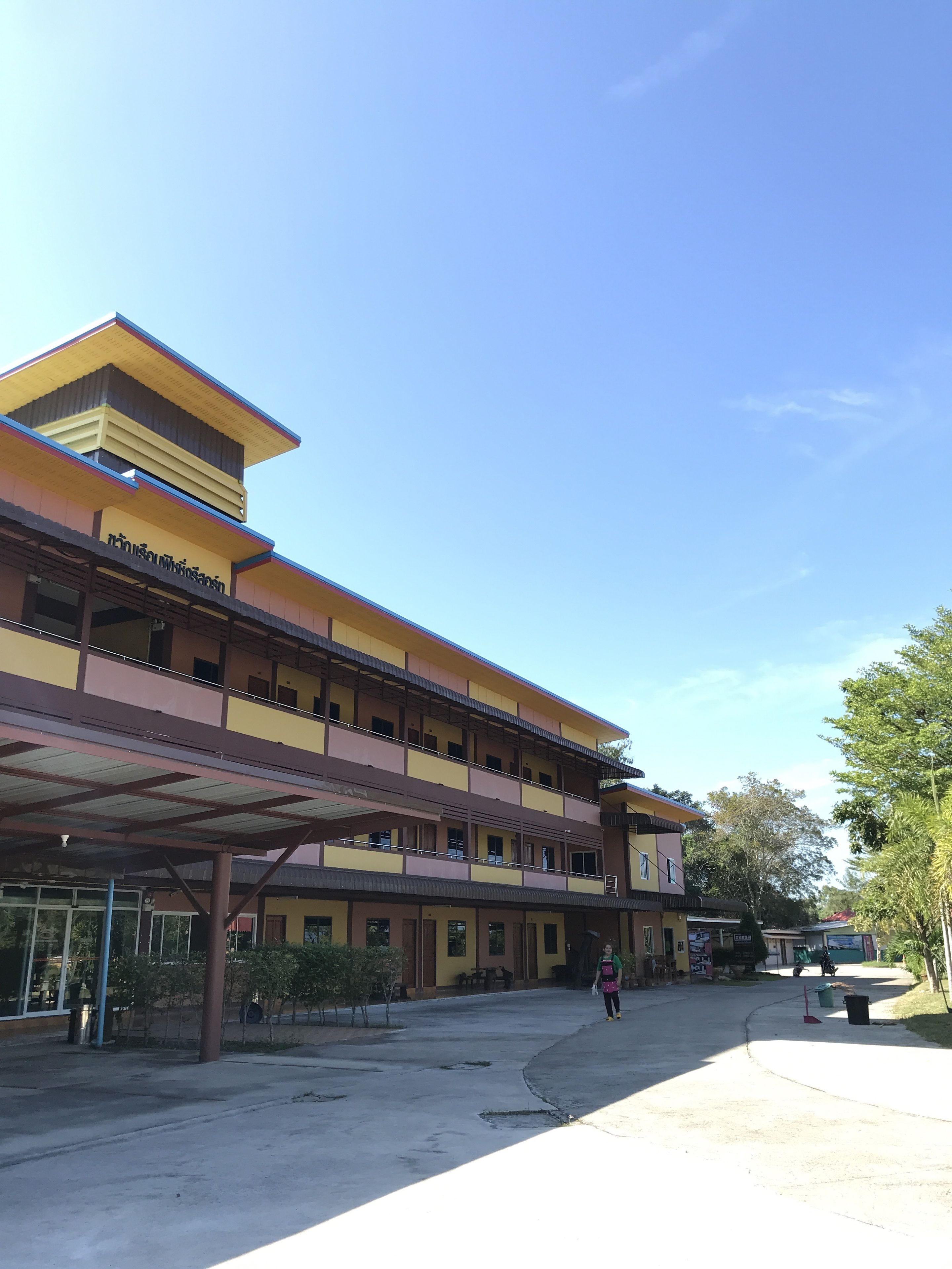 A multi-story building with a flat roof and a covered walkway.