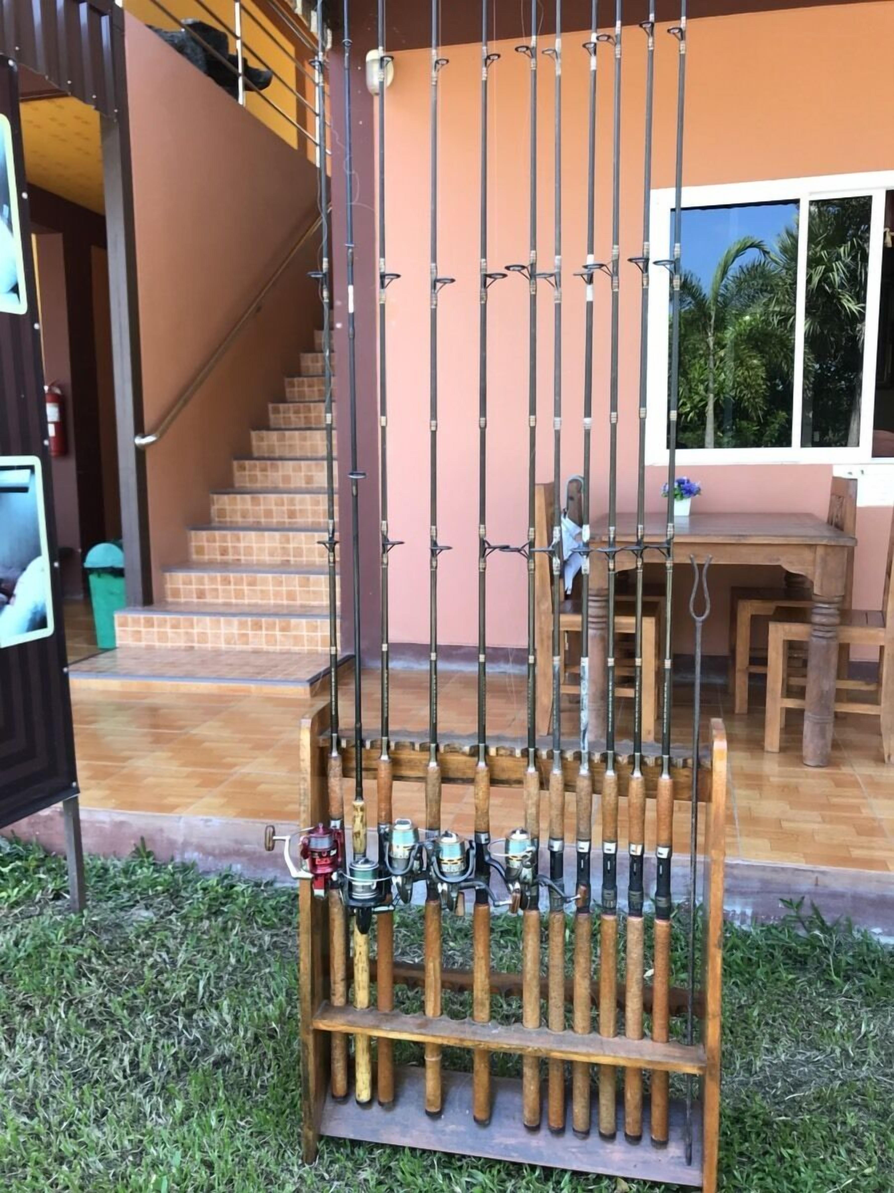 A staircase leading to a second floor, a wooden desk with chairs, and a rack holding fishing rods.