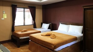 Une chambre d’hôtel avec deux lits, une armoire en bois, une fenêtre avec des rideaux et un luminaire au plafond.