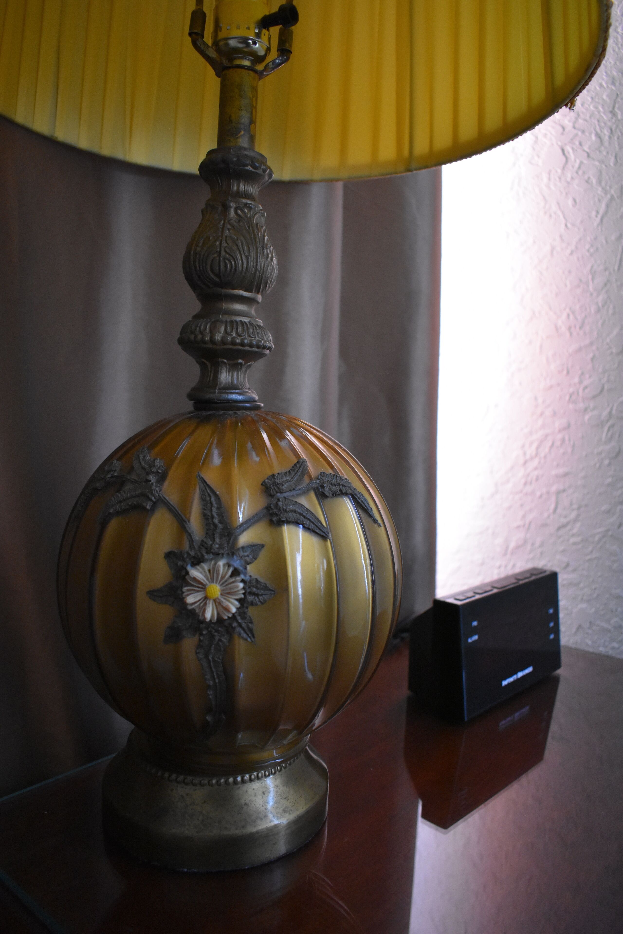 Una lámpara de mesa con diseño floral sobre una superficie de madera.