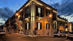 Un edificio de varios pisos con balcones, ventanas amplias y vista a la calle.
