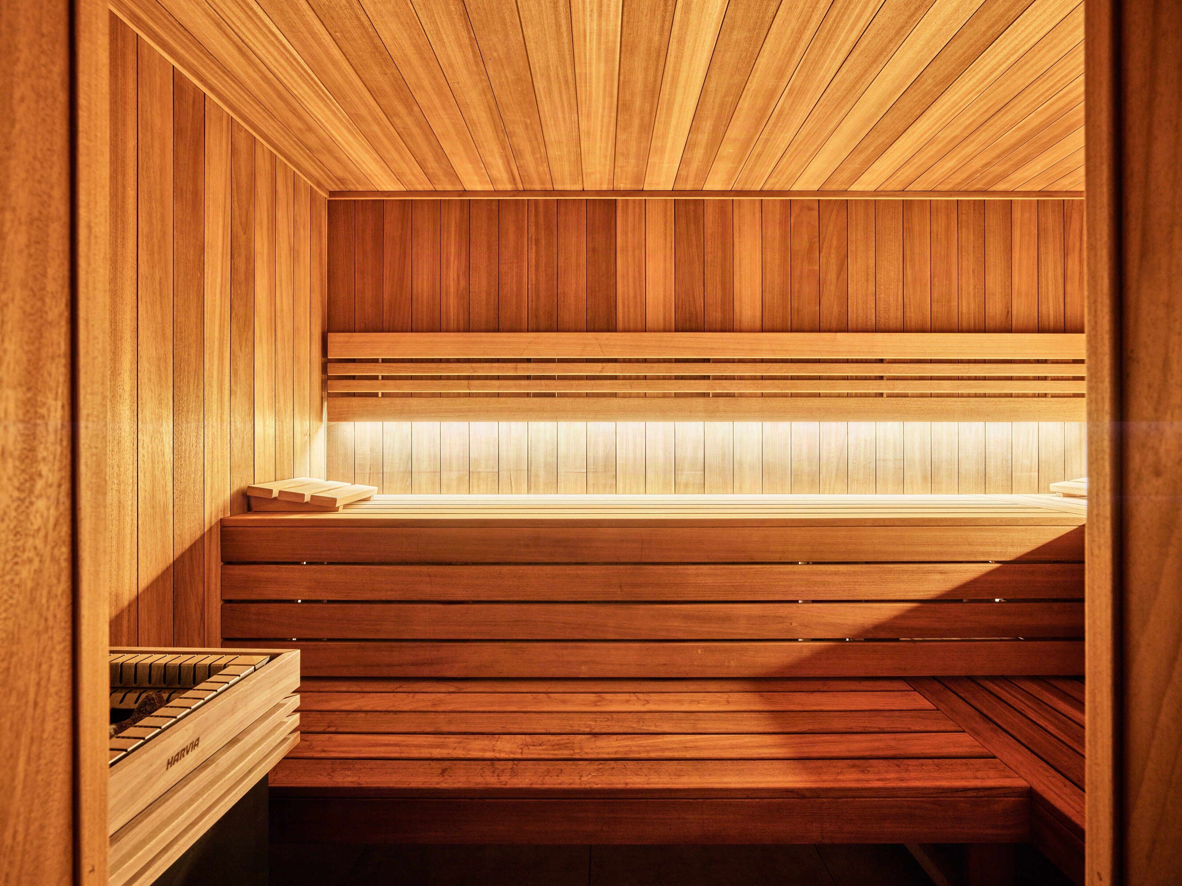 Een houten sauna met banken en een zitbank.