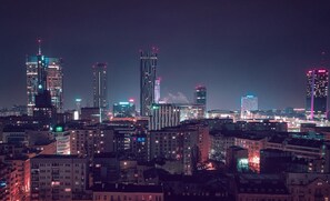 Un paisaje urbano nocturno con rascacielos y ventanas iluminadas.