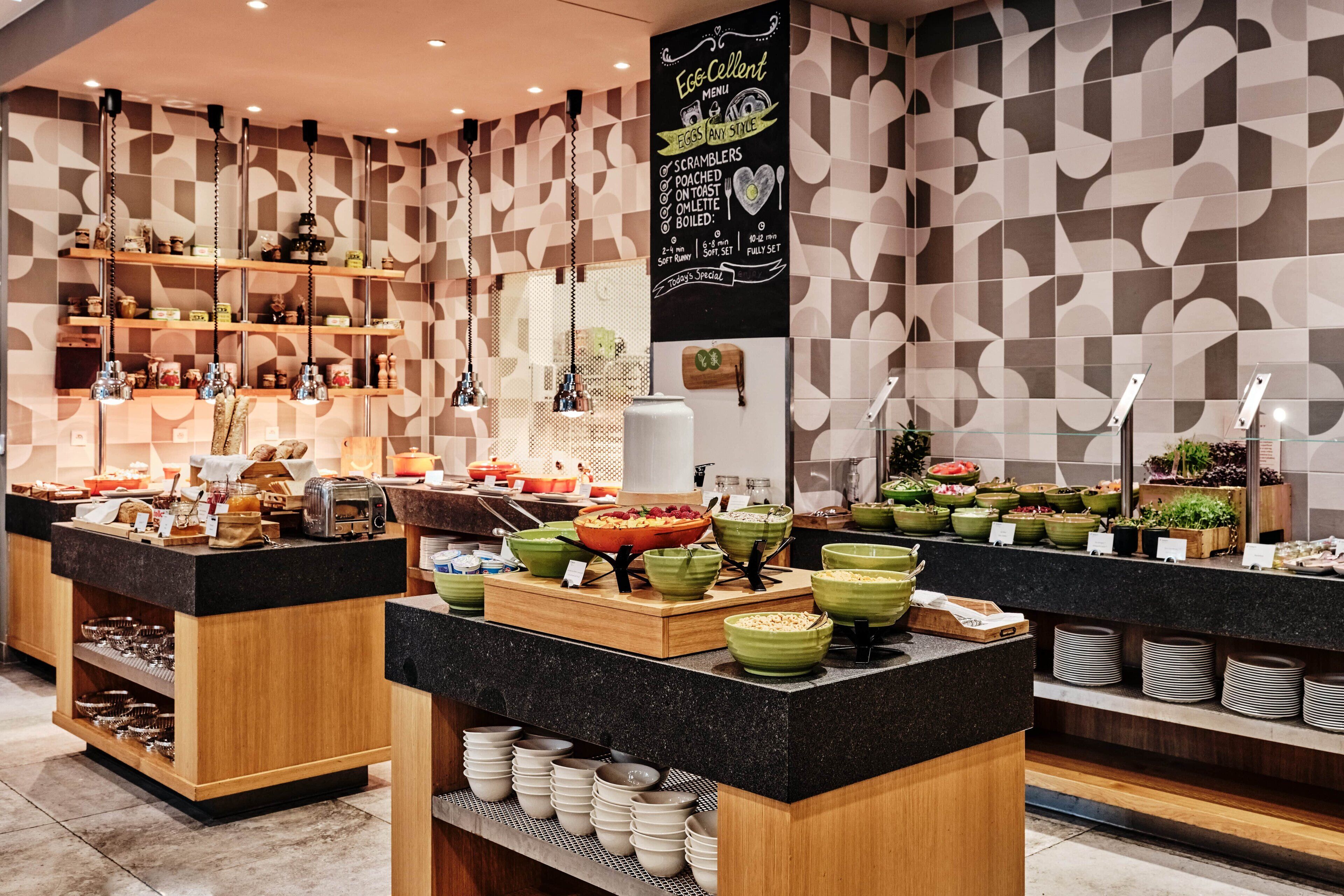A buffet area with various food items and a chalkboard menu.