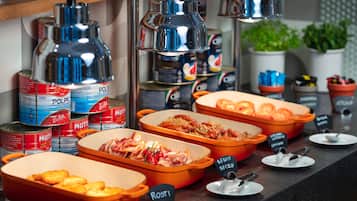 Un bufé con diversos alimentos y fuentes de servicio identificadas.